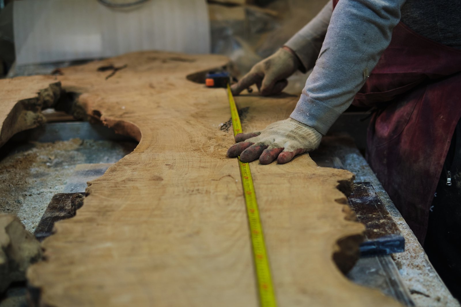 Marking out cuts on a wood slab, accuracy focused. Demonstrates the skill behind custom woodworking