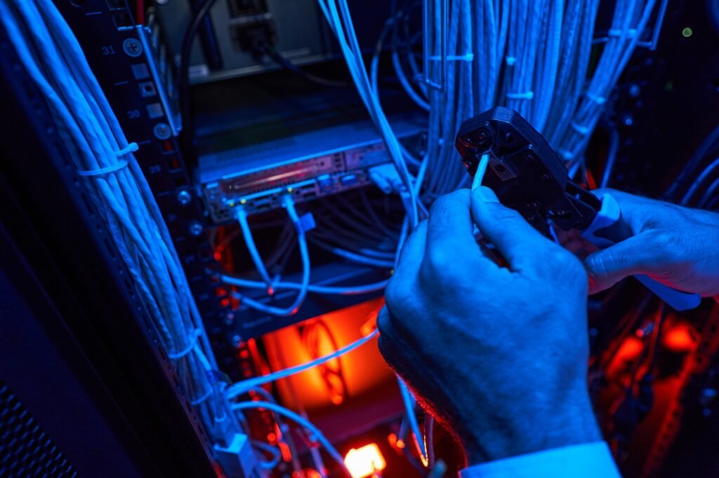 Server technician putting UTP cable into crimping pliers