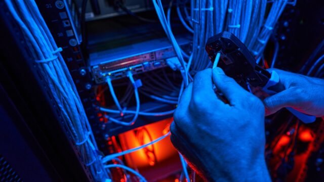 Server technician putting UTP cable into crimping pliers