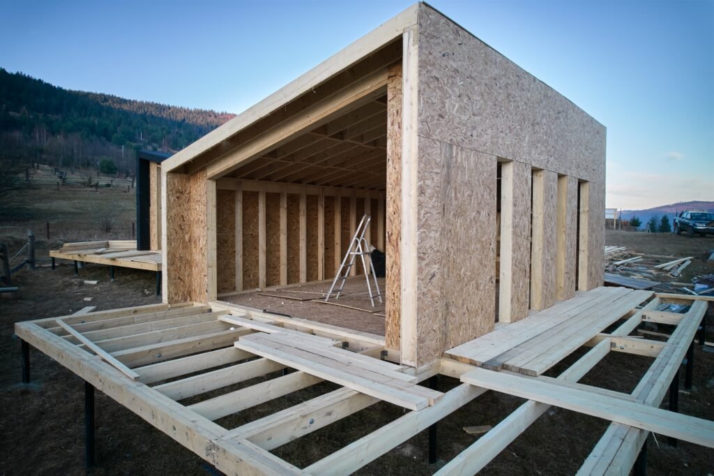 Timber frame house on pile foundation under construction in the mountains.