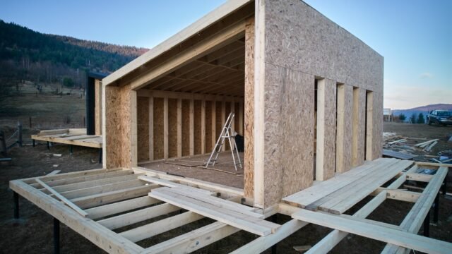 Timber frame house on pile foundation under construction in the mountains.